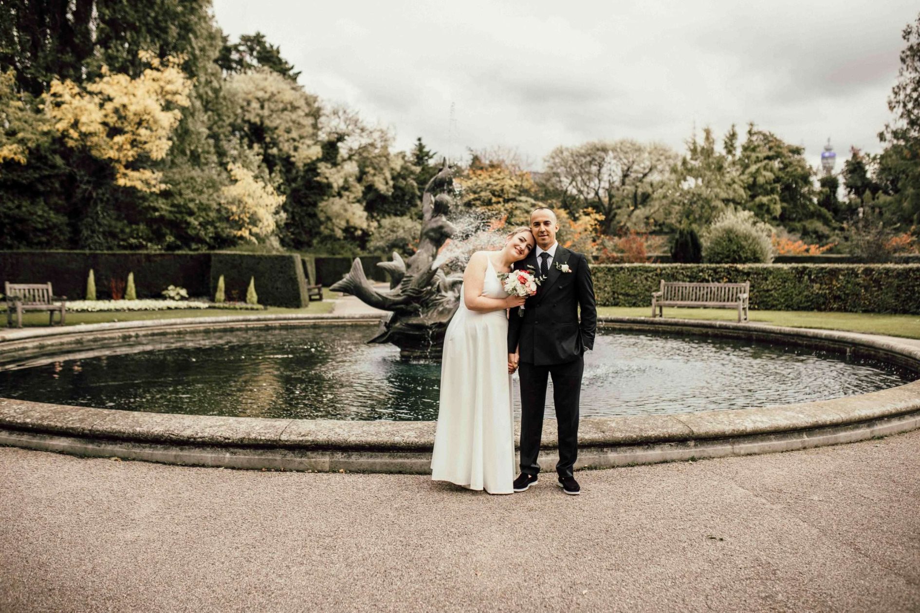 Elegant wedding portrait in The Avenue Gardens, featuring fountains and manicured flower beds.